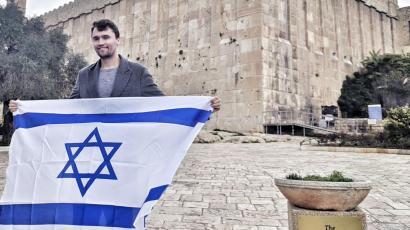 Charlie Kirk hält eine israelische Flagge.